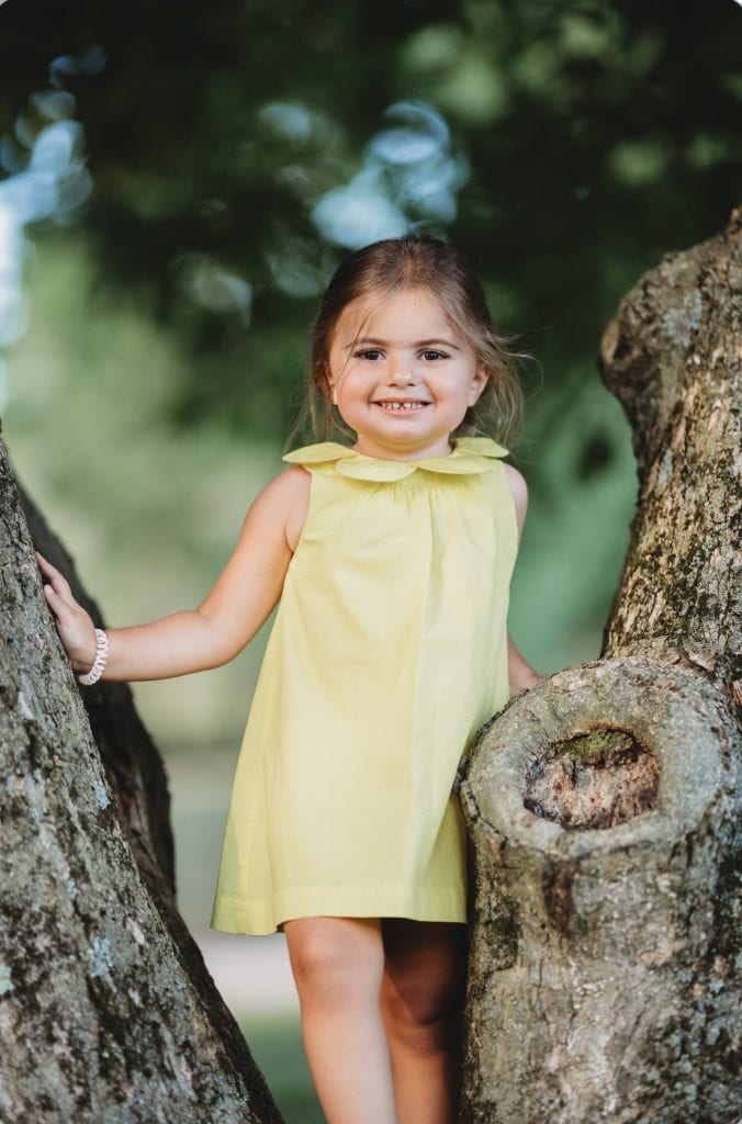 earth day girl in a yellow dress in a tree